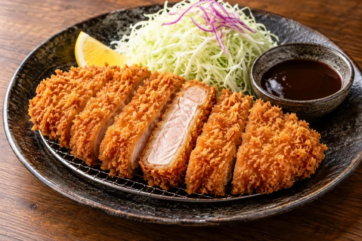 Crispy sliced Japanese tonkatsu with cabbage, lemon and tonkatsu sauce